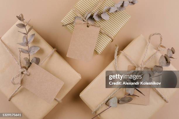 three gift boxes with minimalist style wrapping with craft paper, eucalyptus and label for text - eucalyptus background stock pictures, royalty-free photos & images