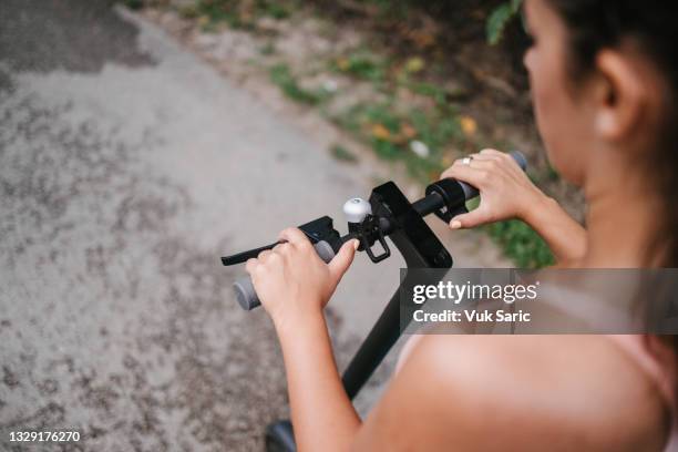 woman holding electric scooter handlebars - brake stock pictures, royalty-free photos & images