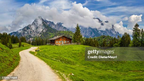 paisaje idílico en los alpes con chalet de montaña y prados en primavera - chalet fotografías e imágenes de stock