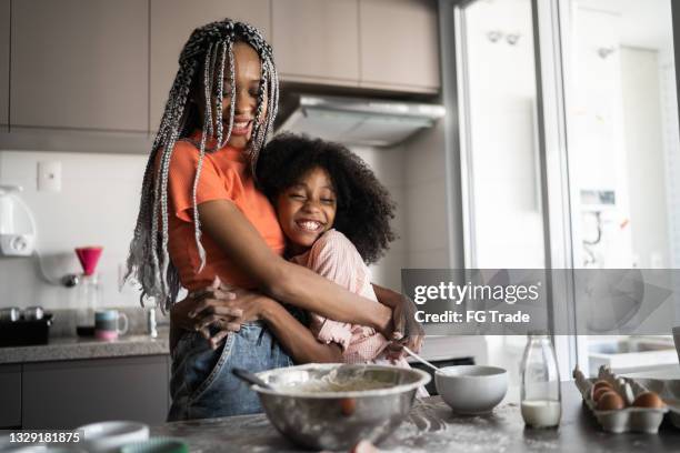 sisters making a cake together at home - braided hairstyles for african american girls stock pictures, royalty-free photos & images
