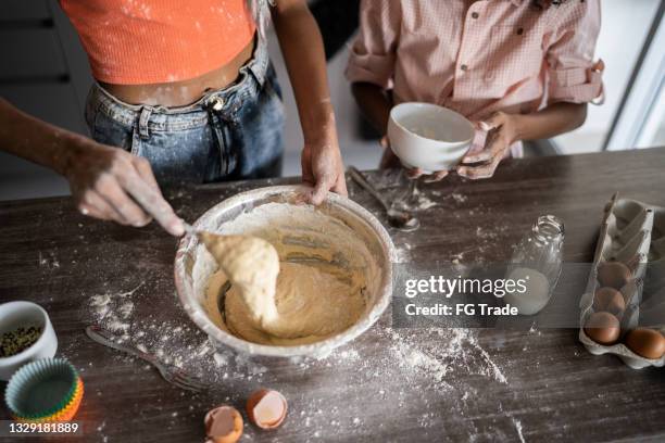 sisters making a cake together at home - messy cake stock pictures, royalty-free photos & images