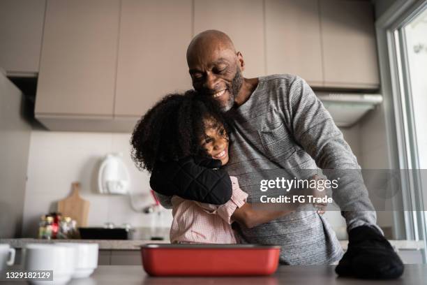 padre e hija abrazando y cocinando juntos en casa - black cook fotografías e imágenes de stock