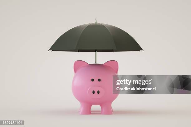 piggy bank with umbrella, financial insurance, protection - warranty stockfoto's en -beelden