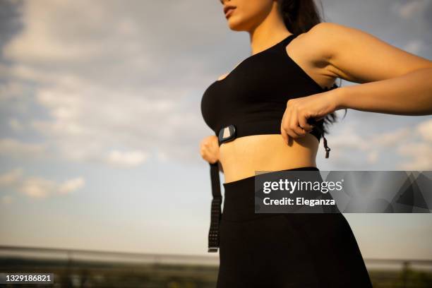 gros plan sur une femme mettant un tracker de fitness pour surveiller ses calories et sa fréquence cardiaque - concepts d’objectifs de fitness - lanière objet manufacturé photos et images de collection