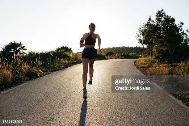 woman running on a road - corrida de rua imagens e fotografias de stock