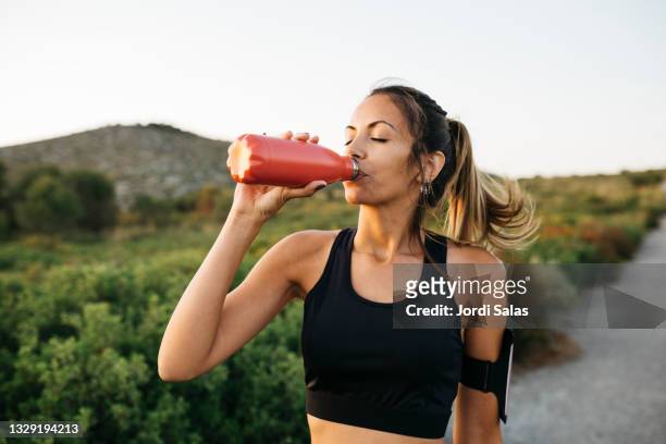 woman drinking water after workout - drink stock-fotos und bilder