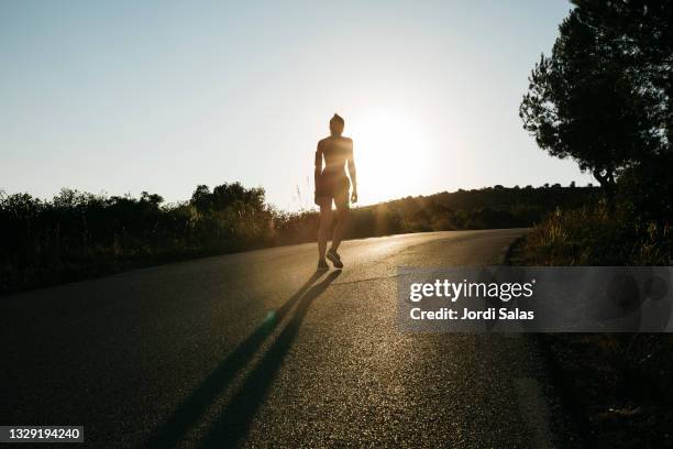 woman running on a road - road running stock pictures, royalty-free photos & images