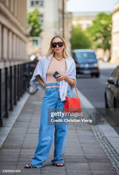 Sonia Lyson is seen wearing Adiletten, denim jeans and sweatshirt Pull & Bear, nude body Zara, red Louis Vuitton bag, Givenchy sunglasses on July 16,...