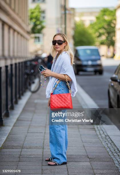 Sonia Lyson is seen wearing Adiletten, denim jeans and sweatshirt Pull & Bear, nude body Zara, red Louis Vuitton bag, Givenchy sunglasses on July 16,...