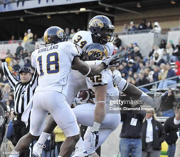 Fullback Tim Erjavec of the Kent State Golden Flashes celebrates after scoring a touchdown with running back Trayion Durham and Sam Kirkland during a...