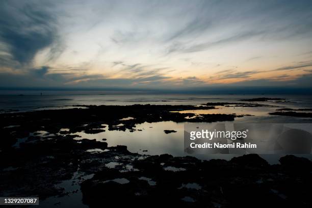 tranquil rock pools and dramatic sky at dusk - 巻雲 ストックフォトと画像