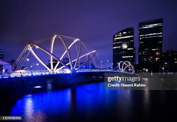 illuminated bridge over river in modern city at night - yarra river stockfoto's en -beelden