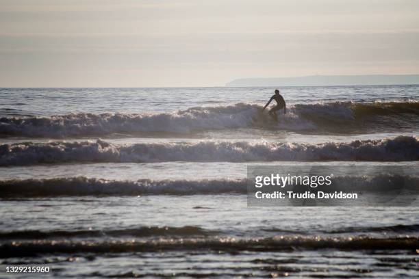 surfer at croyde bay - croyde stock pictures, royalty-free photos & images