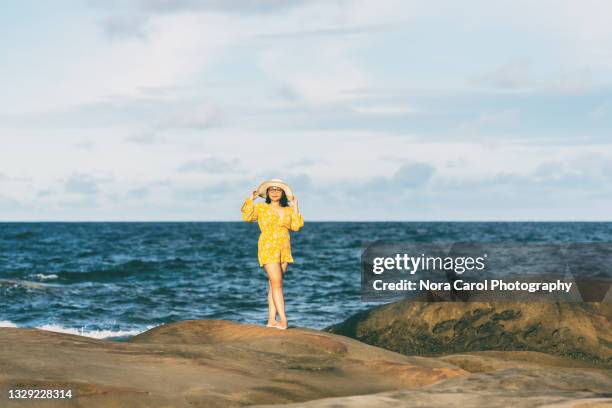 happy woman with yellow jumpsuit and sun hat looking at camera - kota kinabalu beach stock pictures, royalty-free photos & images