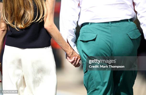 Owner of Aston Martin F1 Team Lawrence Stroll holds hands with his wife Raquel Stroll before the Sprint for the F1 Grand Prix of Great Britain at...