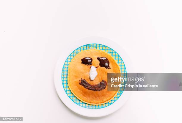 pancake with smiley face of chocolate cream with white background - - breakfast with the best stock-fotos und bilder