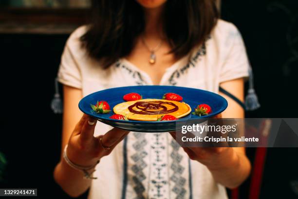 teenage girl with a plate with a pancake with strawberries and chocolate cream ready in home interior - nutella pancake stock pictures, royalty-free photos & images