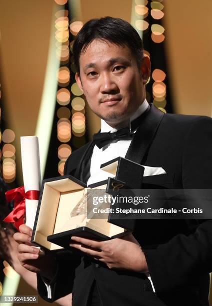 Ryusuke Hamaguchi poses with the 'Best Screenplay Award' for 'Drive my Car' during the closing ceremony of the 74th annual Cannes Film Festival on...