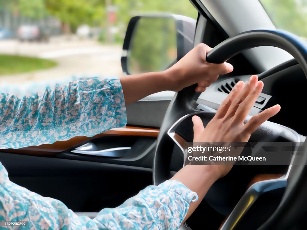 Black woman beeps her car horn in traffic