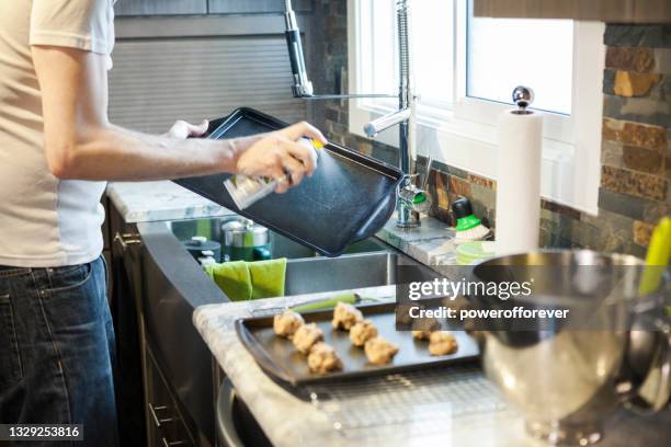 man using cooking spray while baking chocolate chip cookies - aerosol can stock pictures, royalty-free photos & images