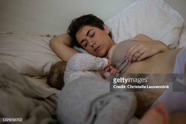 mother at home postpartum with stretch marks from giving birth - baby eating toy stock pictures, royalty-free photos & images