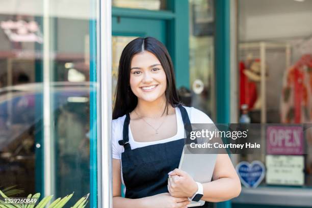small business owner standing outside her store front - small town america stock pictures, royalty-free photos & images