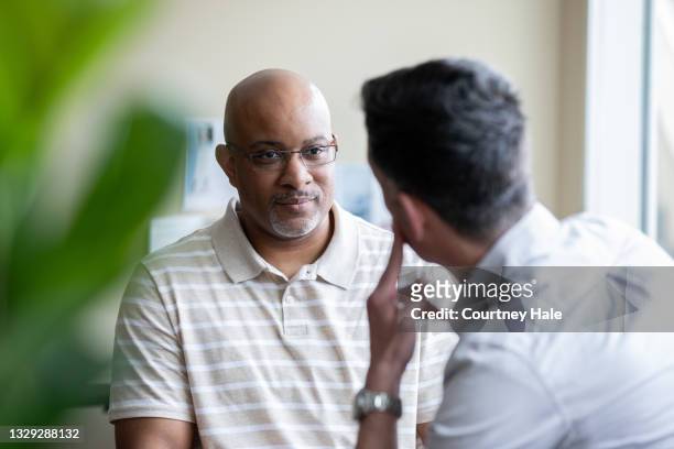 senior man speaking with a counselor in office - masculine office black white bildbanksfoton och bilder