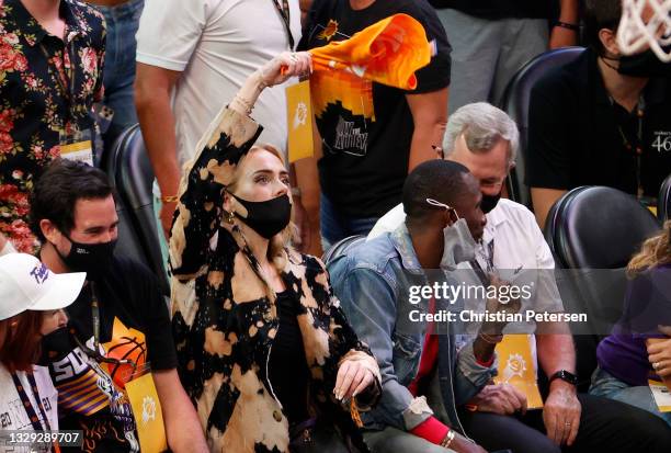 Singer Adele waves a rally towel next to Rich Paul during the second half in Game Five of the NBA Finals between the Milwaukee Bucks and the Phoenix...