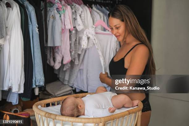 mother choosing clothes for newborn baby - small closet stock pictures, royalty-free photos & images