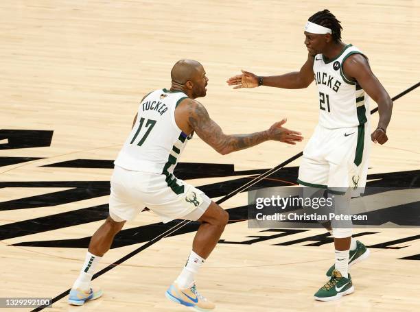 Tucker and Jrue Holiday of the Milwaukee Bucks celebrate a team win against the Phoenix Suns in Game Five of the NBA Finals at Footprint Center on...
