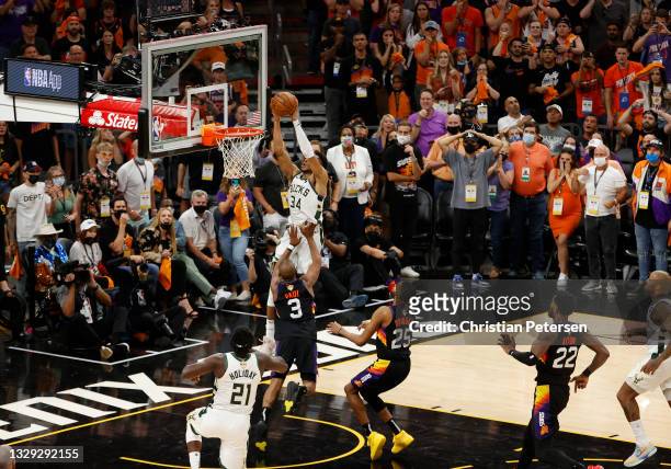 Giannis Antetokounmpo of the Milwaukee Bucks dunks against Chris Paul of the Phoenix Suns during the second half in Game Five of the NBA Finals at...