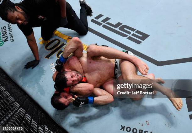 Islam Makhachev of Russia secures a rear choke submission against Thiago Moises of Brazil in their lightweight bout during the UFC Fight Night event...