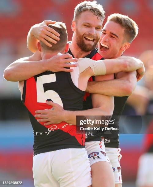 Devon Smith of Essendon celebrates with Jake Stringer of Essendon and team mates during the round 18 AFL match between North Melbourne Kangaroos and...