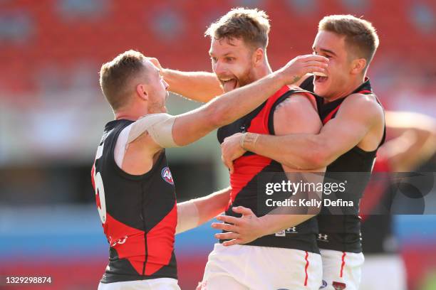 Devon Smith of Essendon celebrates with Jake Stringer of Essendon and team mates during the round 18 AFL match between North Melbourne Kangaroos and...