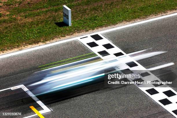 German Mercedes AMG Formula One racing driver Nico Rosberg driving his MGP W02 racing car at speed across the black and white checkered pattern start...