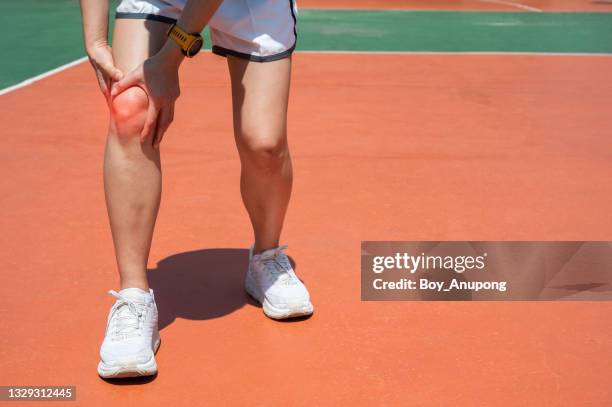 woman holding her knee while she having suffering from knee pain after hard workout. - tendon stock pictures, royalty-free photos & images