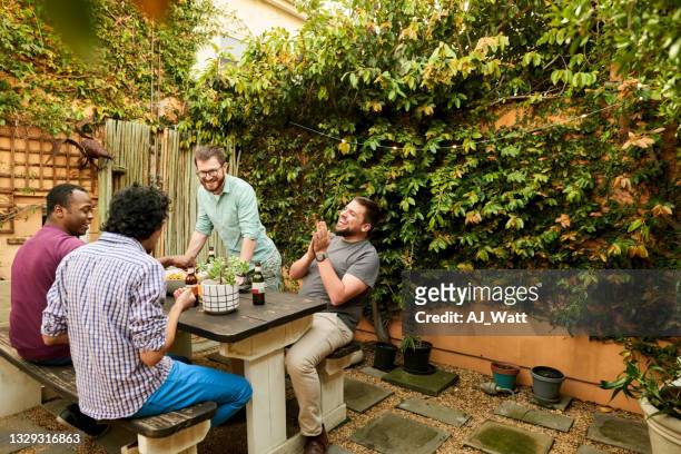 group of male friends having a party in backyard - only young men stock pictures, royalty-free photos & images
