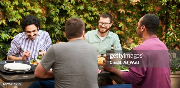 männliche freunde beim abendessen und bier im hinterhof - nur junge männer stock-fotos und bilder