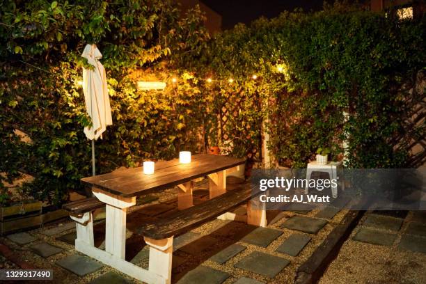 table with candle lights in backyard garden in evening - formal garden party stock pictures, royalty-free photos & images