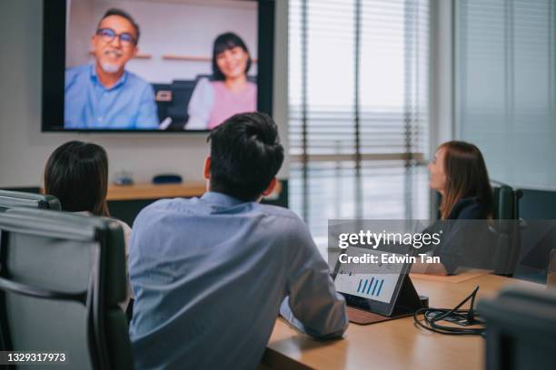 asia white collar worker having video conference videocall with company staff meeting discussion in the conference room board of directors have video call with foreign investor. business meeting with mergers and acquisitions - digital fulfillment stockfoto's en -beelden