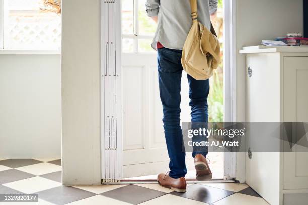 junger mann, der durch eine tür in seiner küche nach draußen geht - bis bald stock-fotos und bilder