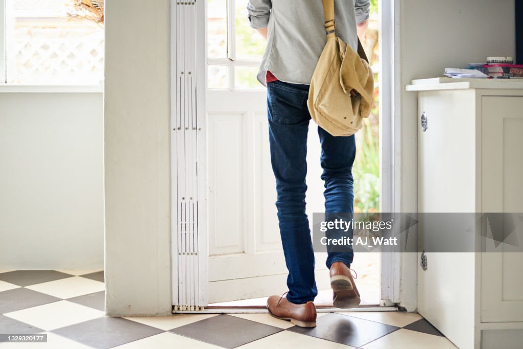 Young man walking outside through a door in his kitchen