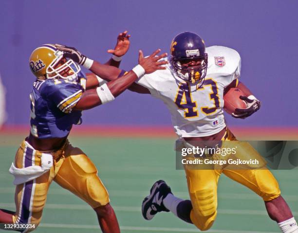 Running back Robert Walker of the West Virginia University Mountaineers fights off the tackle of defensive back Anthony Dorsett of the University of...