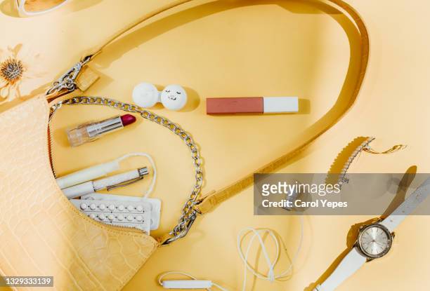 contents of woman bag in yellow background.top view - purse contents stock pictures, royalty-free photos & images