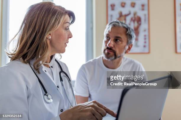 photo of a female mature  doctor  taking anamnesis from her mature patient - mature men talking stock pictures, royalty-free photos & images