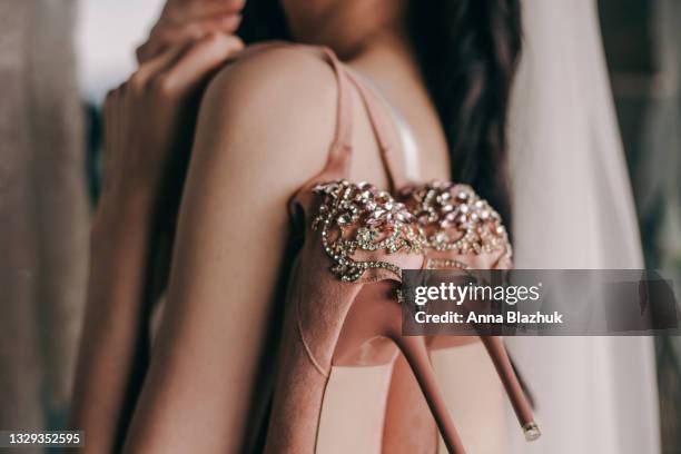 morning of bride. young woman holding shoes and wearing veil preparing for wedding. - wedding veil photos et images de collection