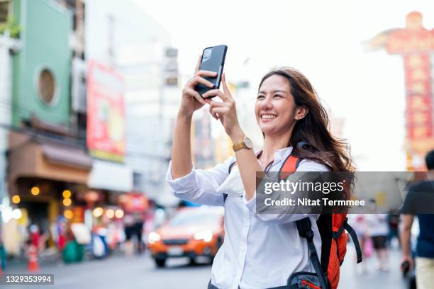 asian women with backpacks taking selfies on the bangkok chinatown, yaowarat street market. traveling, lifestyle. - taken on mobile device stock pictures, royalty-free photos & images