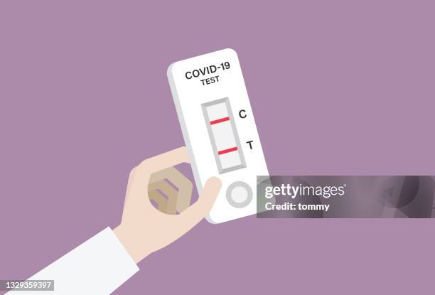 hand holding a covid-19 rapid test with a positive result - lateral flow test stock illustrations