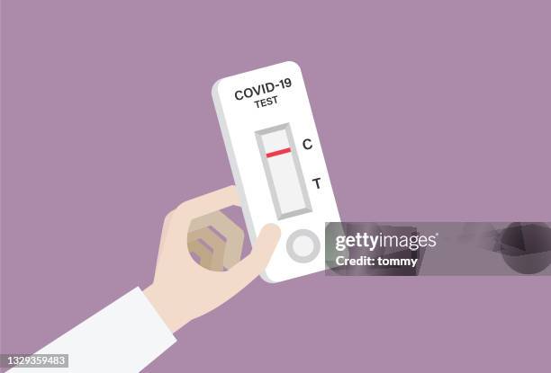 stockillustraties, clipart, cartoons en iconen met hand holding a covid-19 rapid test with a negative result - biohazardous substance