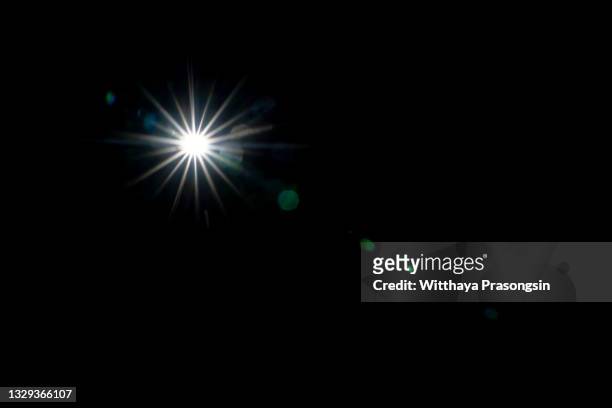 light star on black background - glittering foto e immagini stock